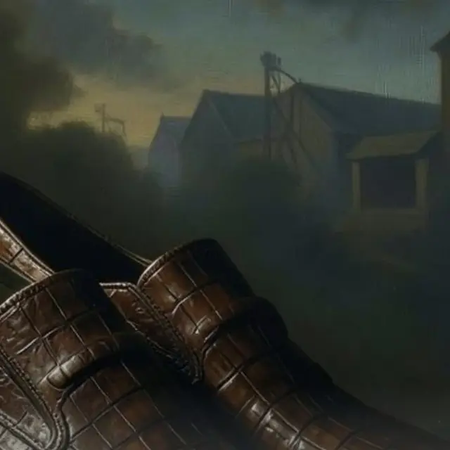 Brown crocodile shoes in a moody warehouse-style scene